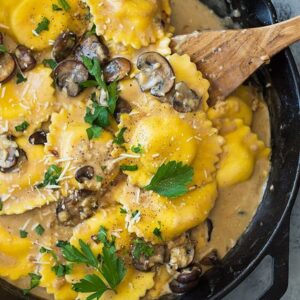 This Cheese Ravioli in Creamy Mushroom Sauce is made easy using store bought ravioli and made extra decadent with a simple garlic mushroom cream sauce! | www.countrysidecravings.com