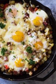 This Cheesy Corned Beef Hash with Baked Eggs is an easy one pan breakfast recipe! Filled with meat, potatoes and eggs makes for a hearty and satisfying breakfast! | www.countrysidecravings.com