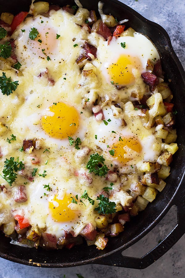 This Cheesy Corned Beef Hash with Baked Eggs is an easy one pan breakfast recipe! Filled with meat, potatoes and eggs makes for a hearty and satisfying breakfast! | www.countrysidecravings.com