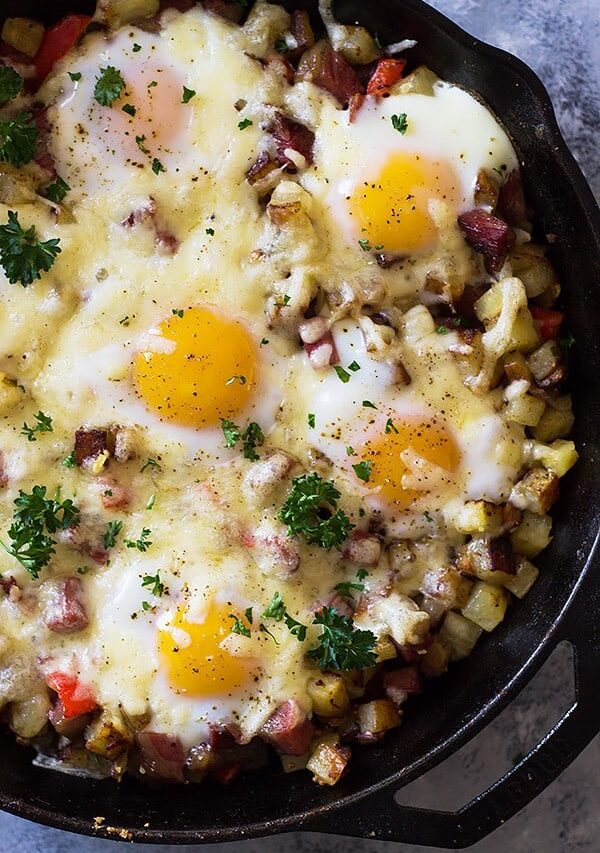 This Cheesy Corned Beef Hash with Baked Eggs is an easy one pan breakfast recipe! Filled with meat, potatoes and eggs makes for a hearty and satisfying breakfast! | www.countrysidecravings.com