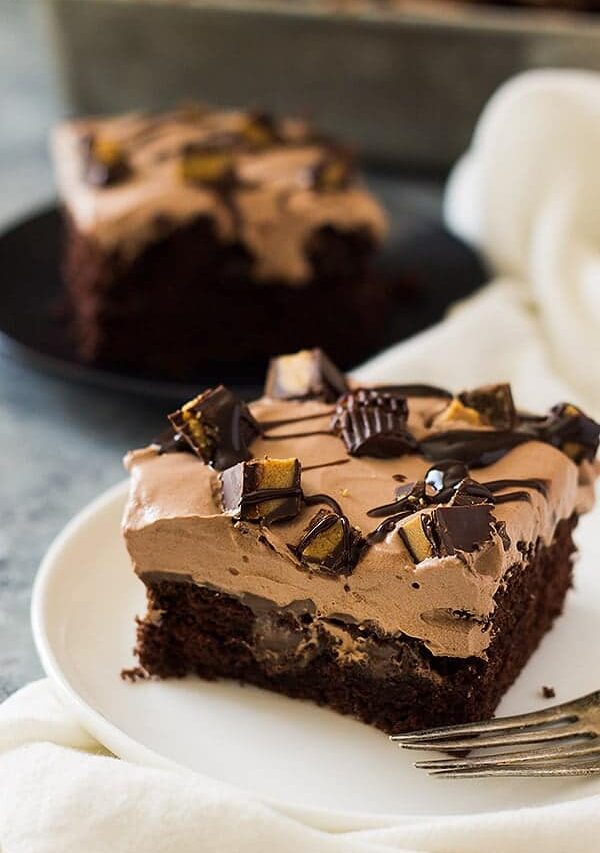 This Chocolate Peanut Butter Poke Cake is a chocolate cake soaked in peanut butter goodness! Then topped with a luscious chocolate whipped cream and peanut butter cups! | www.countrysidecravings.com