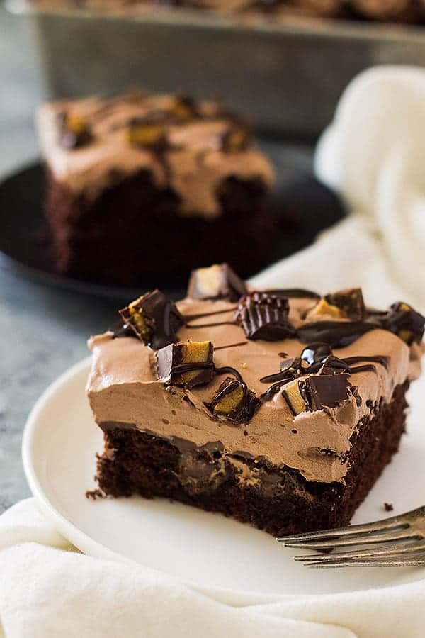 This Chocolate Peanut Butter Poke Cake is a chocolate cake soaked in peanut butter goodness! Then topped with a luscious chocolate whipped cream and peanut butter cups! | www.countrysidecravings.com