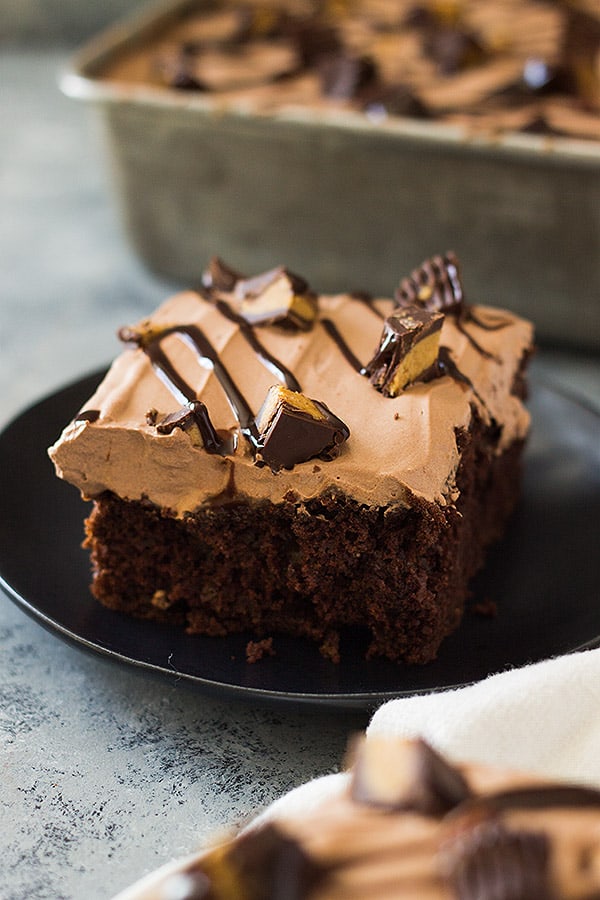 This Chocolate Peanut Butter Poke Cake is a chocolate cake soaked in peanut butter goodness! Then topped with a luscious chocolate whipped cream and peanut butter cups! | www.countrysidecravings.com