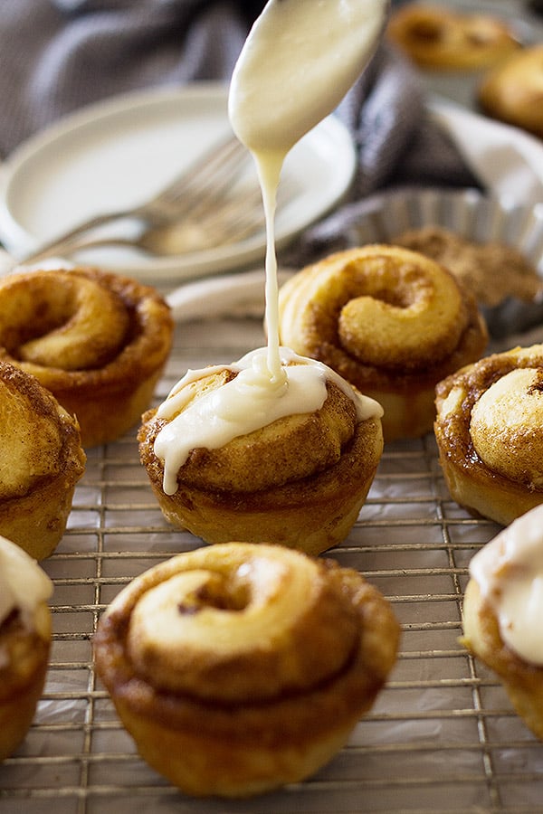 These Cinnamon Roll Muffins are a tender homemade yeast roll made in a muffin tin! Topped with a delicious vanilla icing makes these the perfect breakfast! | www.countrysidecravings.com