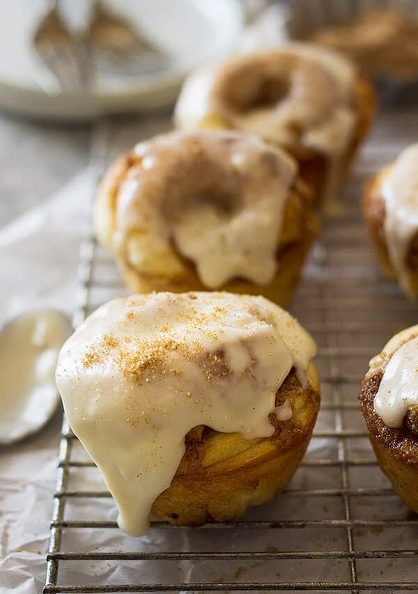 These Cinnamon Roll Muffins are a tender homemade yeast roll made in a muffin tin! Topped with a delicious vanilla icing makes these the perfect breakfast! | www.countrysidecravings.com