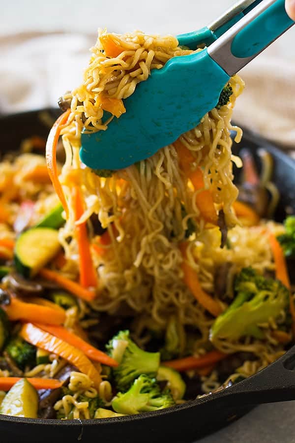 tongs with ramen with vegetables
