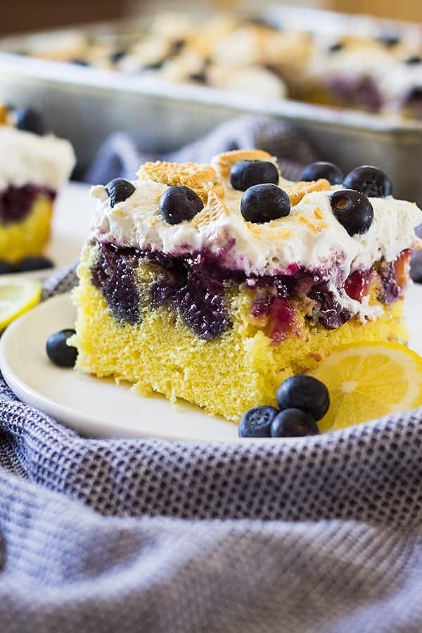 This Lemon Blueberry Poke Cake is perfect for spring and summer! It's make with a lemon cake then drizzled with lemon curd and a blueberry syrup. 