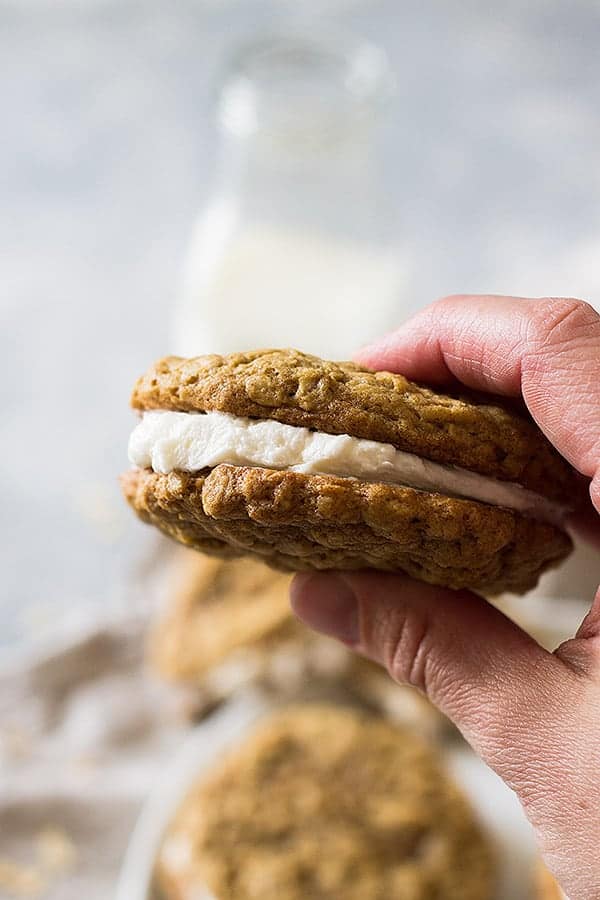 Hand holding oatmeal cream pies with more in background. 