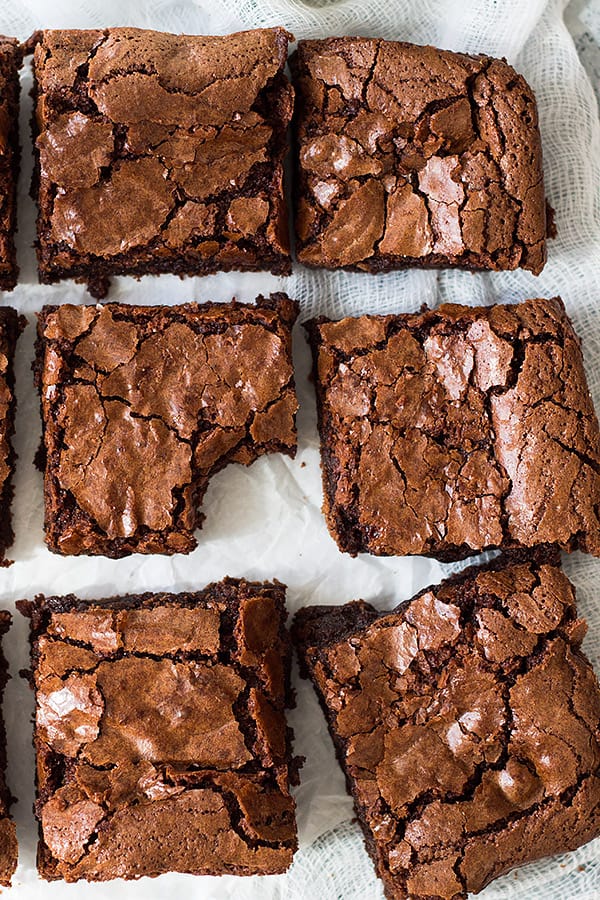 Close up of brownies cut into squares to show crackly top. 