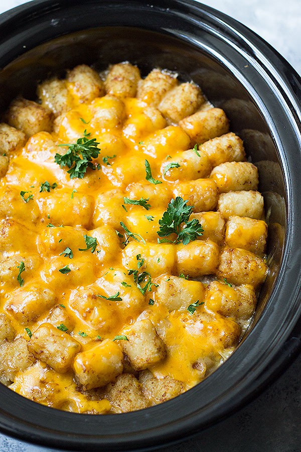 Crockpot with Bacon Cheeseburger Tater Tot Casserole garnished with parsley. 