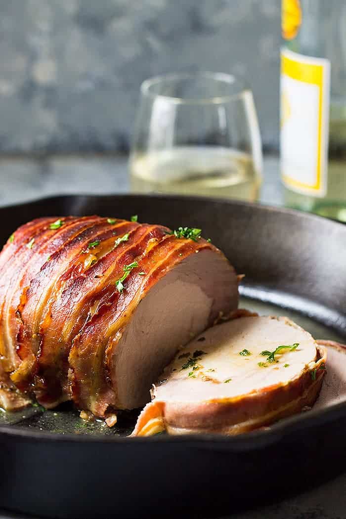 Bacon Wrapped Pork Loin sliced in cast iron skillet