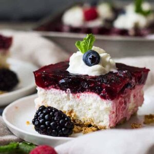 This Triple Berry Pretzel Salad is the perfect sweet and salty combo, with the salty pretzel crust, cream cheese middle, and fruity jello top! It's perfect at potlucks or family gatherings.