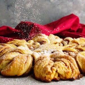 Powdered sugar sprinkling over the top of the snowflake bread.