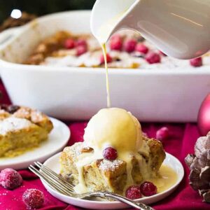 This Cranberry Bread Pudding with Whiskey Cream Sauce is an indulgent dessert! Brioche bread baked in a cinnamon custard then topped with a whiskey cream sauce!