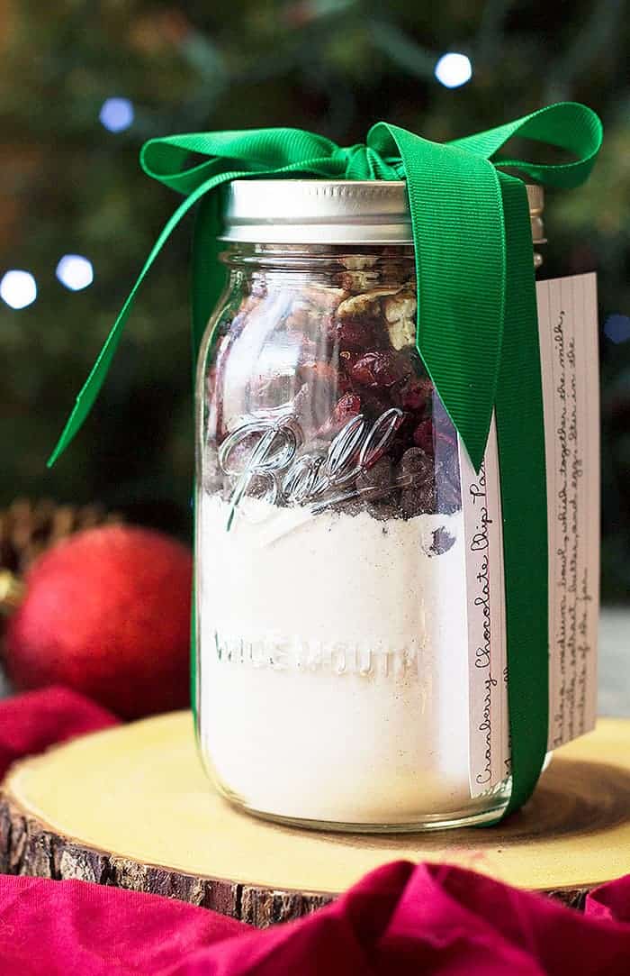 Mason jar of Cranberry Chocolate Chip Pancake mix packaged with a green ribbon. 