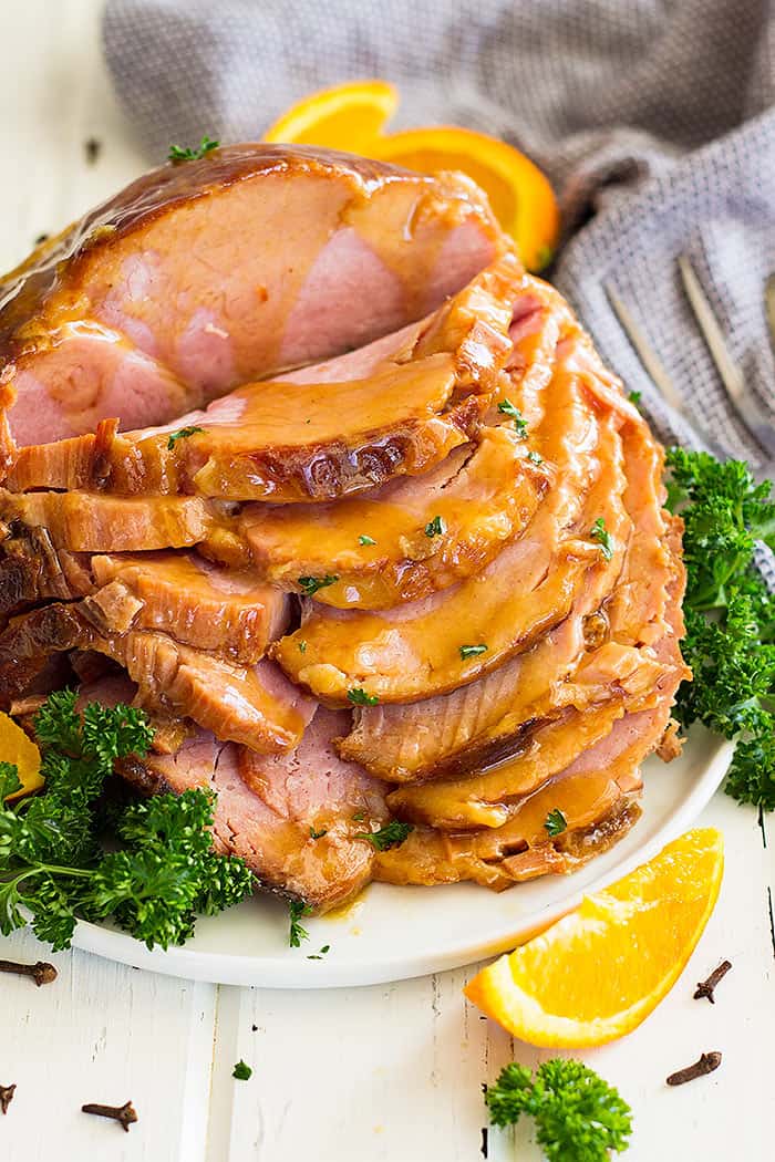 Slow cooker honey mustard ham being sliced on a plate.