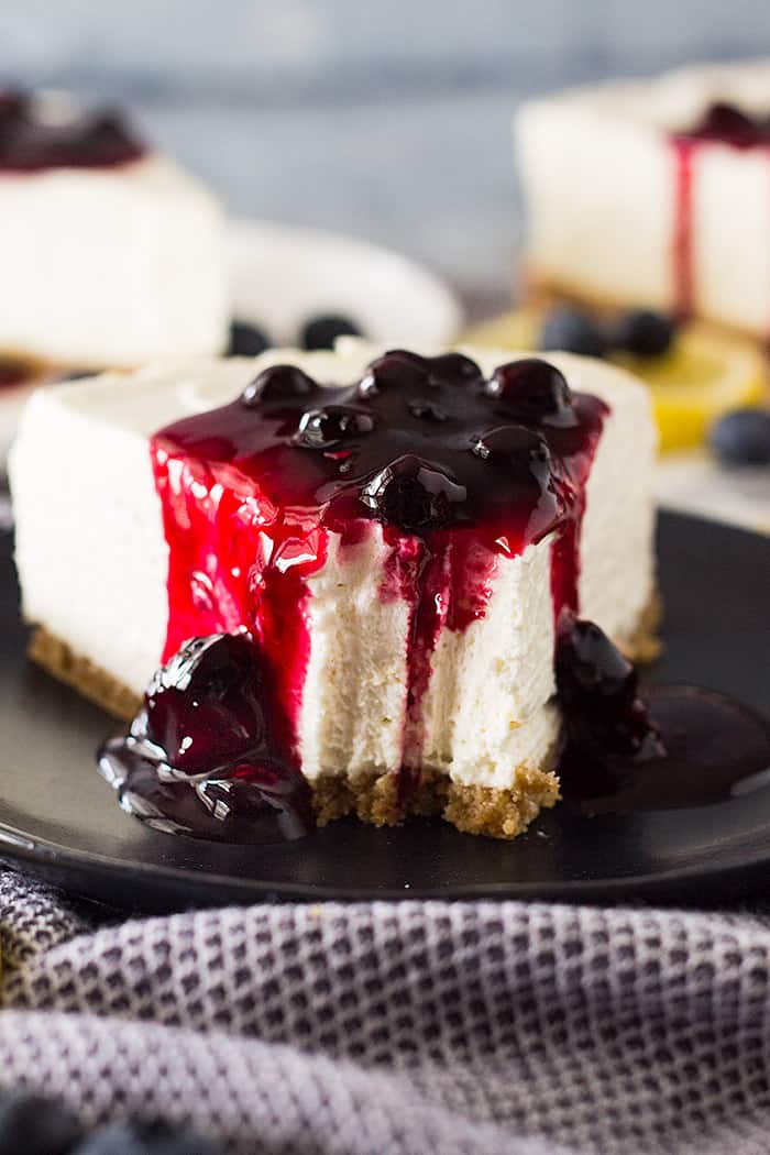 Slice of No Bake Lemon Blueberry Cheesecake with a bite taken out.