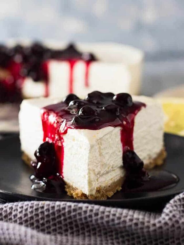 Close up of a slice of No Bake Lemon Blueberry Cheesecake with blueberry sauce on top.