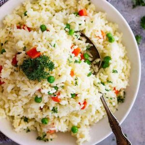 Easy Rice Pilaf with Carrots and Peas is a quick and easy side dish that pairs well with so many dishes! Great for casual weeknight dinners or for company. #rice #easyrecipe #ricepilaf