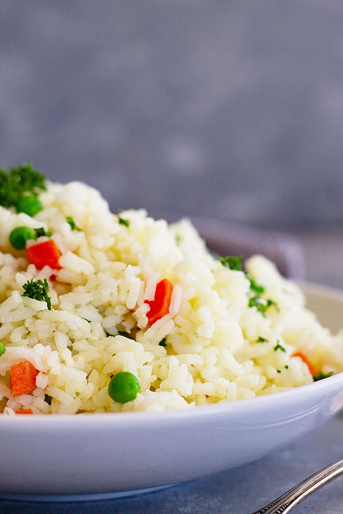 This Easy Rice Pilaf with Carrots and Peas is a staple recipe everyone should learn! It goes great with so many dishes and is so easy to make!