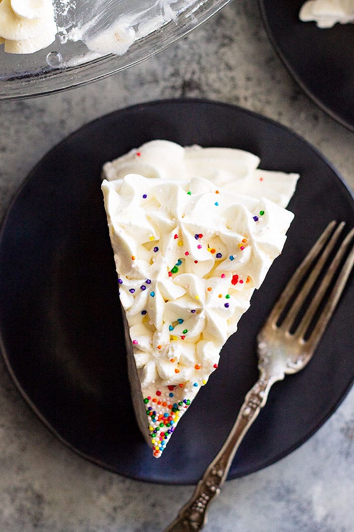 This Brownie Ice Cream Cake is perfect for summer birthdays! A chewy brownie on the bottom, topped with hot fudge sauce, vanilla ice cream, and a homemade whipped cream! #brownie #icecream #cake