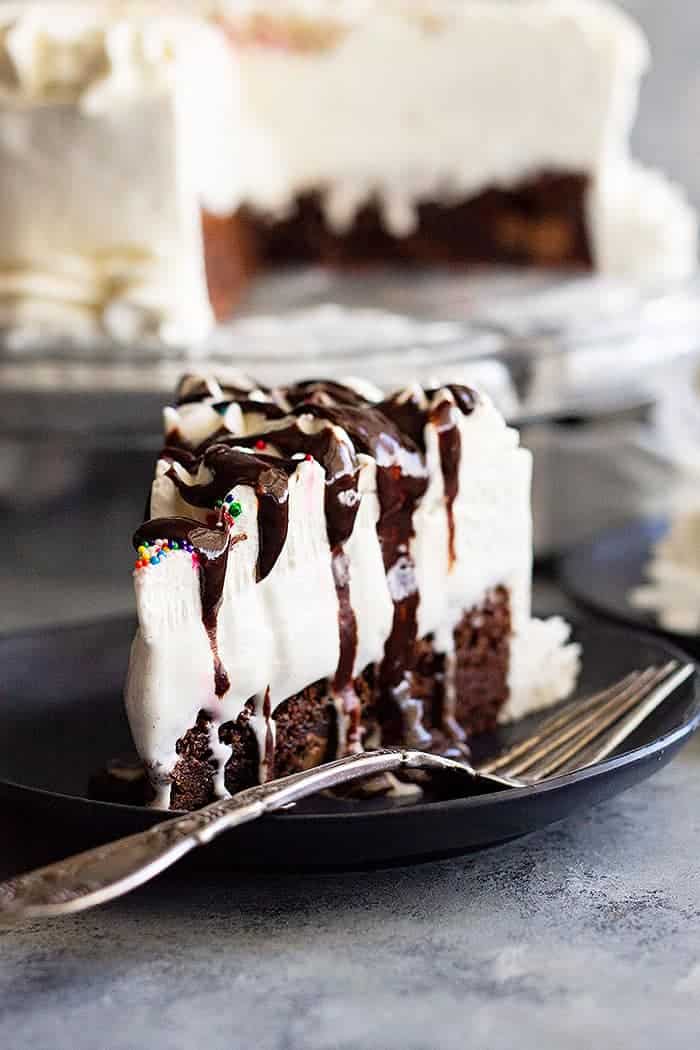This Brownie Ice Cream Cake is an easy way to impress your guests. Chewy brownie on the bottom, topped with hot fudge sauce, vanilla ice cream, and a homemade whipped cream topping. #brownie #icecream #cake