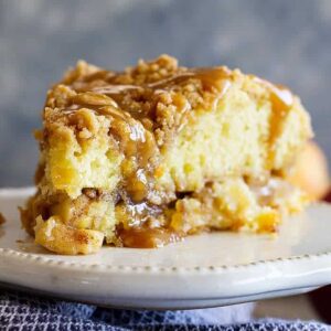 This Apple Crumb Cake is the perfect fall treat! It's filled with spiced apples, an extra thick crumb layer, and a tender cake. Drizzle with an easy homemade caramel sauce for the perfect treat!