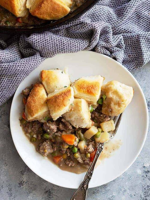 This easy Skillet Beef Pot Pie will please the whole family. It's filled with ground beef and vegetables in an easy homemade gravy. Top with store bought or homemade biscuits for the ultimate comfort food! #potpie #groundbeef #easyrecipe #beefpotpie