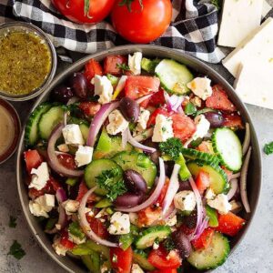 Greek Salad is a quick and simple salad that’s full of flavor and crunch. Greek Salad Ingredients are bright fresh and delicious. Pair this salad with leftover rotisserie chicken or seafood for a delicious and healthy meal! #greeksalad #healthysalad