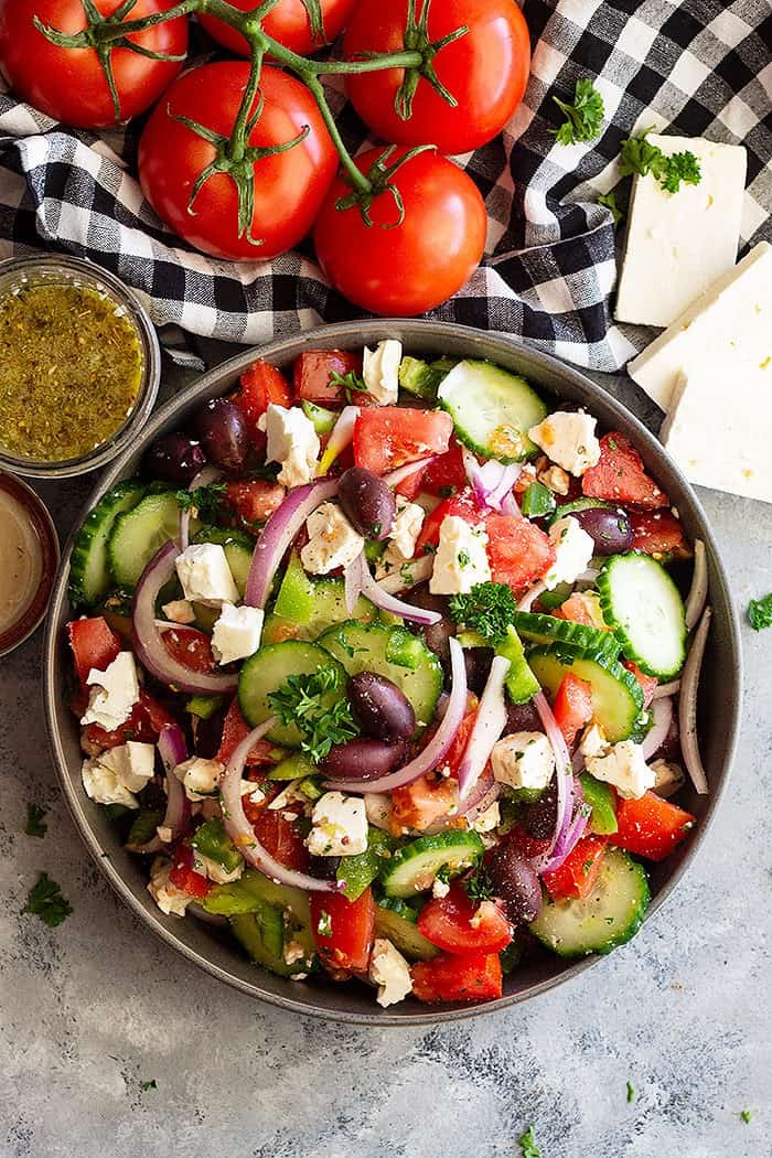 Top down view of a large bowl of Greek Salad full of fresh vegetables.
