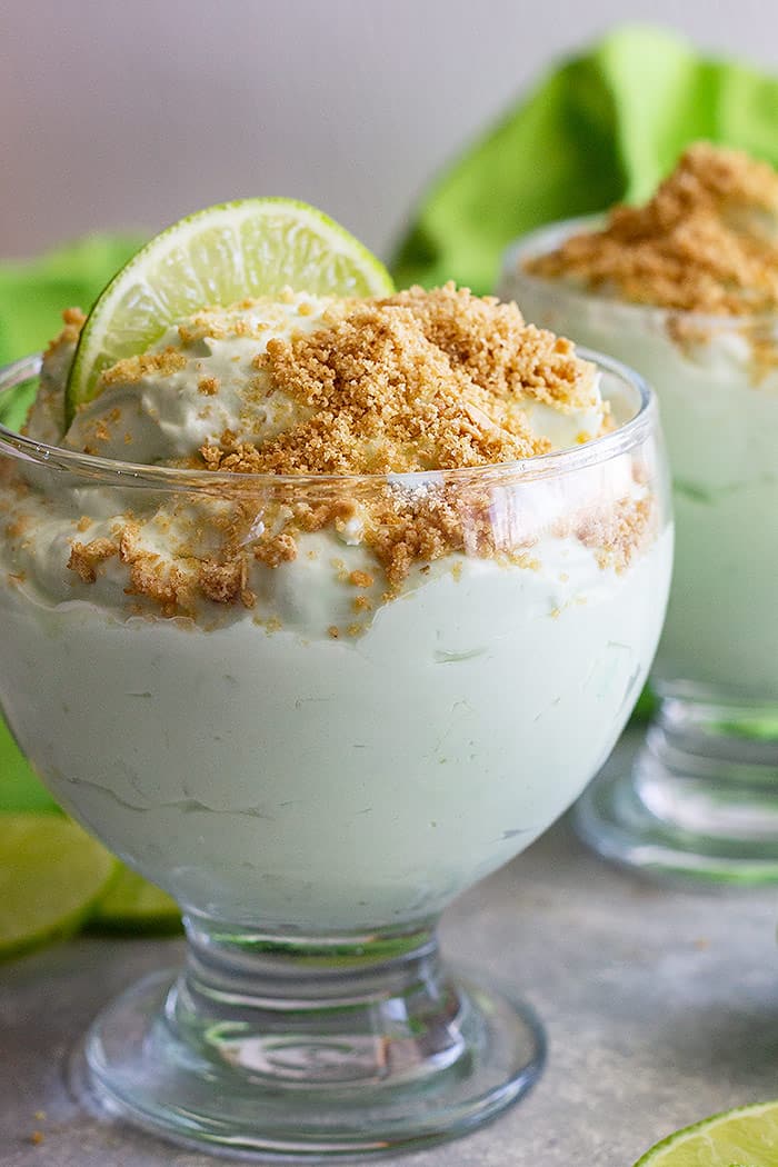 A dessert bowl filled with lime cheesecake fluff and topped with graham cracker crumbs. 