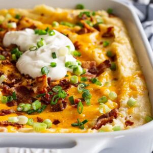 This Loaded Mashed Potato Casserole is the perfect make ahead side dish! It's filled with bacon and cheese and feeds a crowd! #loadedpotatoes #mashedpotatoes