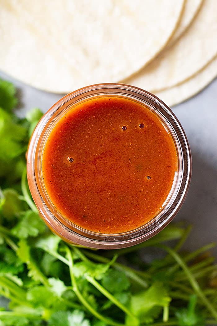 Top down view of a jar of homemade enchilada sauce. 