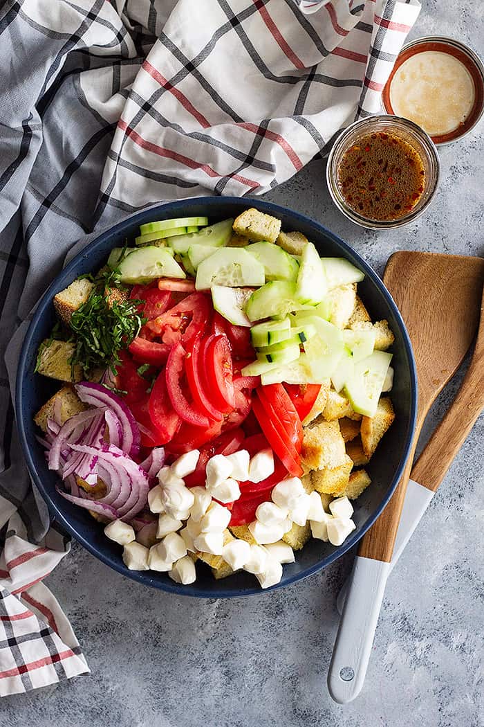 Ingredients for Panzanella Salad with Mozzarella arranged in a bowl ready to be mixed. 