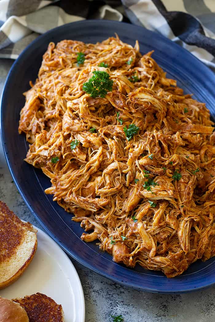 A large serving platter filled with slow cooker bbq chicken. 