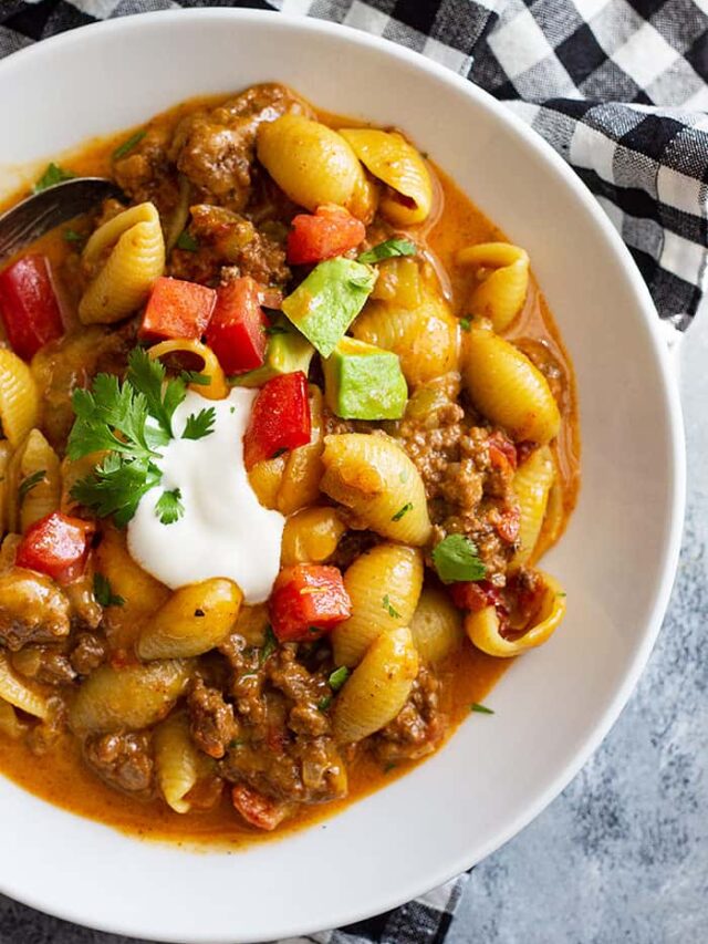 top down picture of a bowl of taco pasta topped with taco toppings.