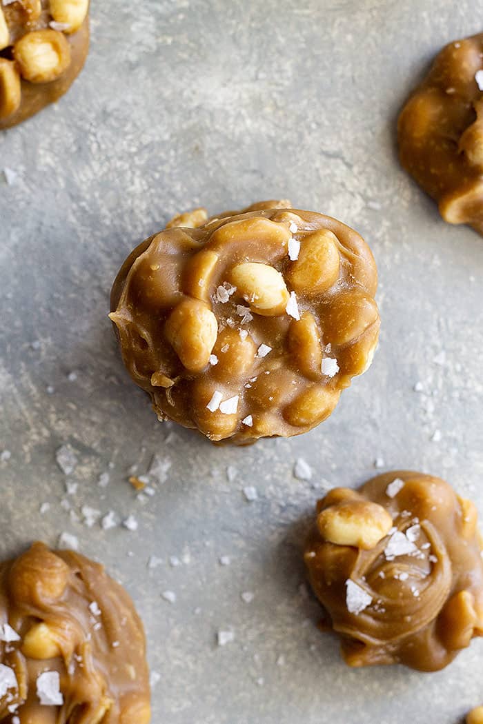 Top down view of a few easy peanut pralines stacked and sprinkled with flaky sea salt.