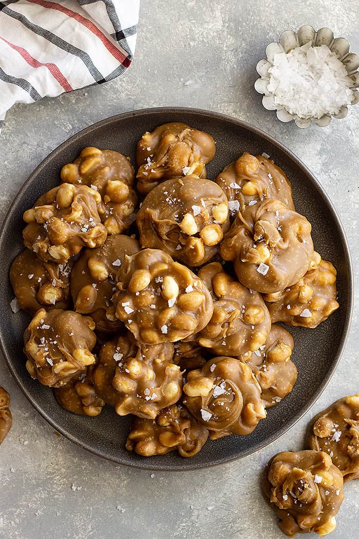 Top down view of easy peanut pralines on a plate and flaky sea salt scattered. 