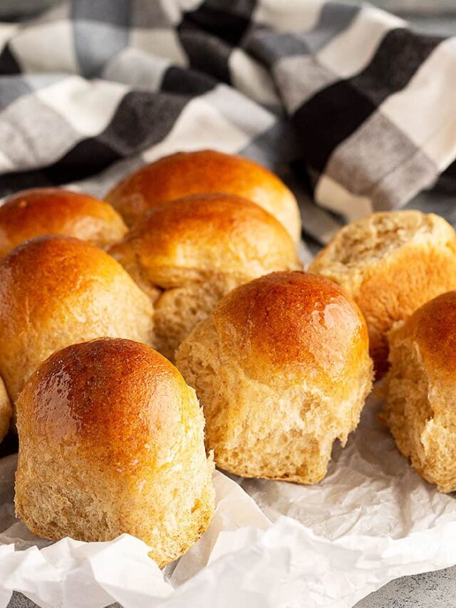 Honey wheat rolls fresh from the oven and lightly brushed with melted butter.