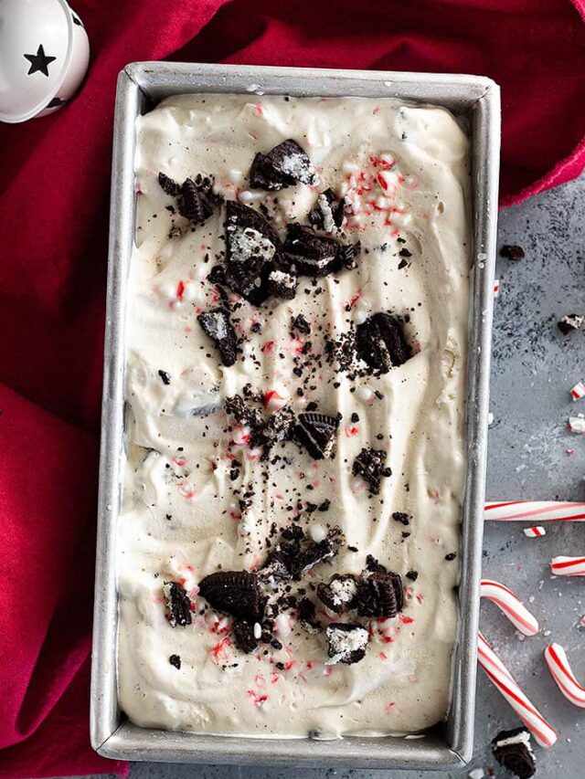 No Churn Peppermint Ice Cream in a pan decorated with chopped peppermints and oreos.