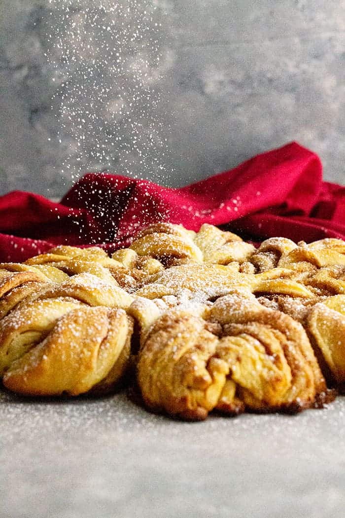 Powdered sugar sprinkling over the top of the snowflake bread.