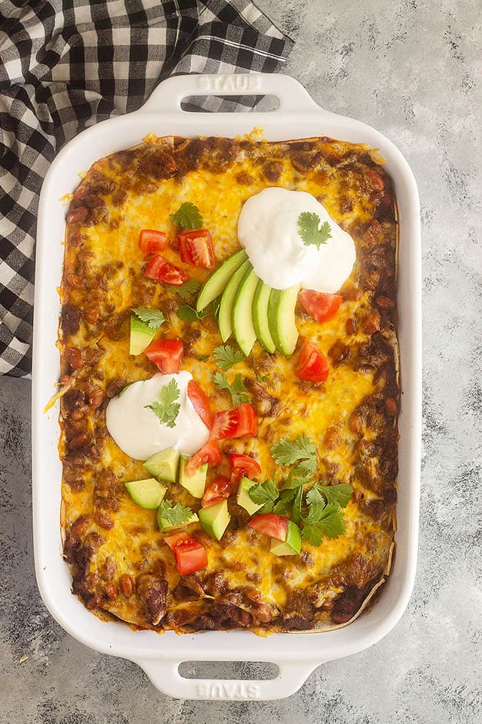 Top down picture of Mexican Casserole topped with sour cream, avocado, and tomatoes. 