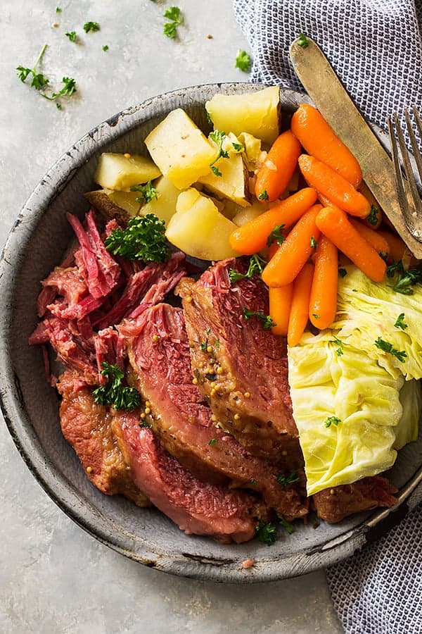 Top down view of sliced corned beef, cabbage, carrots, and potatoes. 