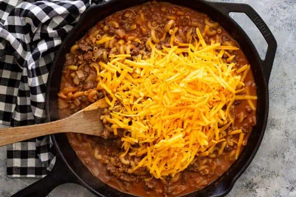 Overhead view of adding cheese to the skillet.