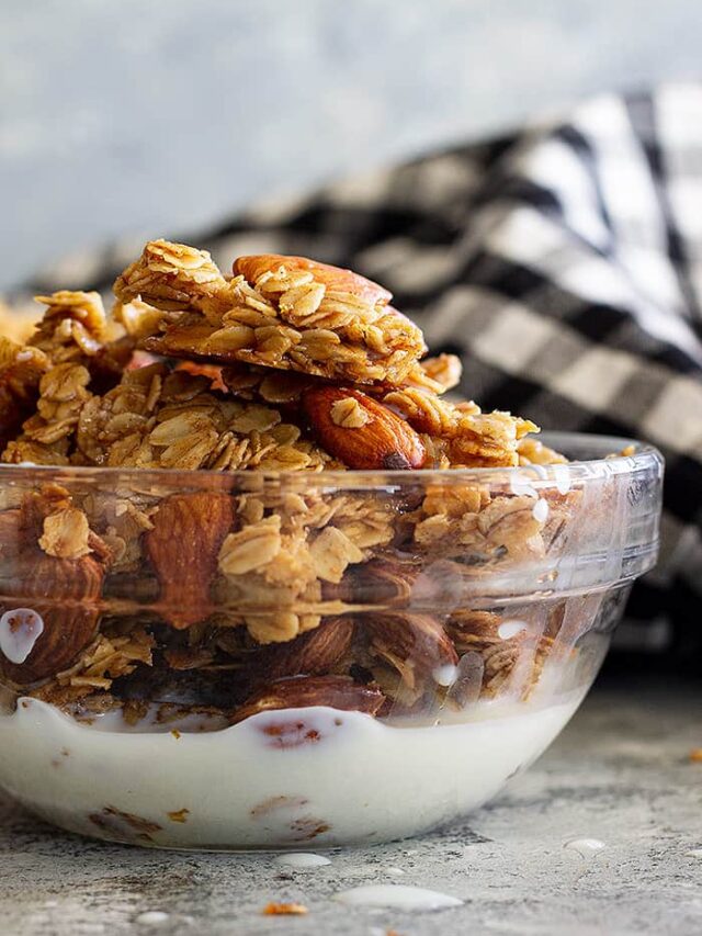 A bowl of honey almond granola with a splash of milk.