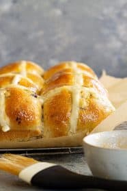 Close up of hot cross buns in a baking pan.
