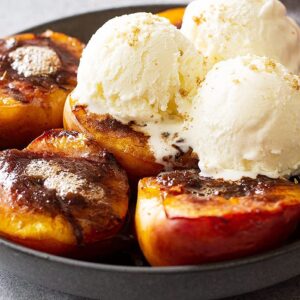 Grilled peaches topped with vanilla ice cream.
