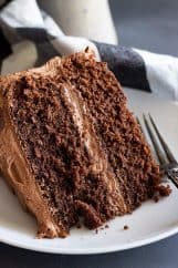 A close up of a slice of delicious moist chocolate cake with chocolate frosting.