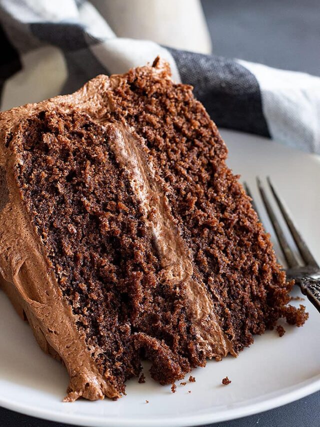 A close up of a slice of delicious moist chocolate cake with chocolate frosting.