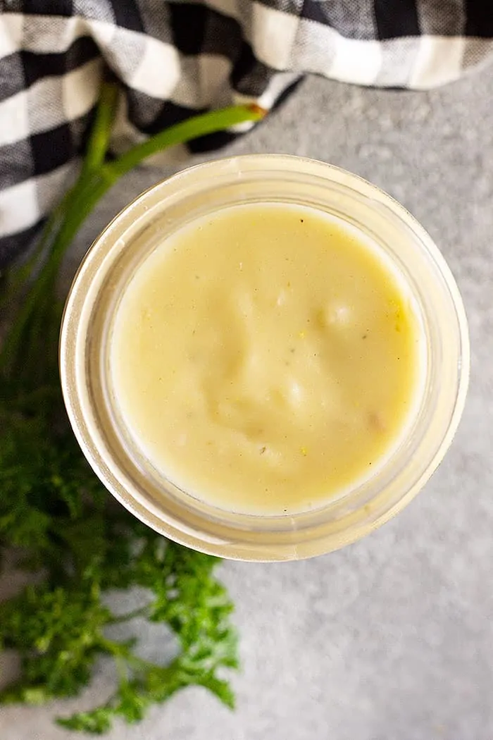 Overhead view of cream of chicken soup made from scratch in a jar. Decorated with fresh parsley and a napkin to the side. 